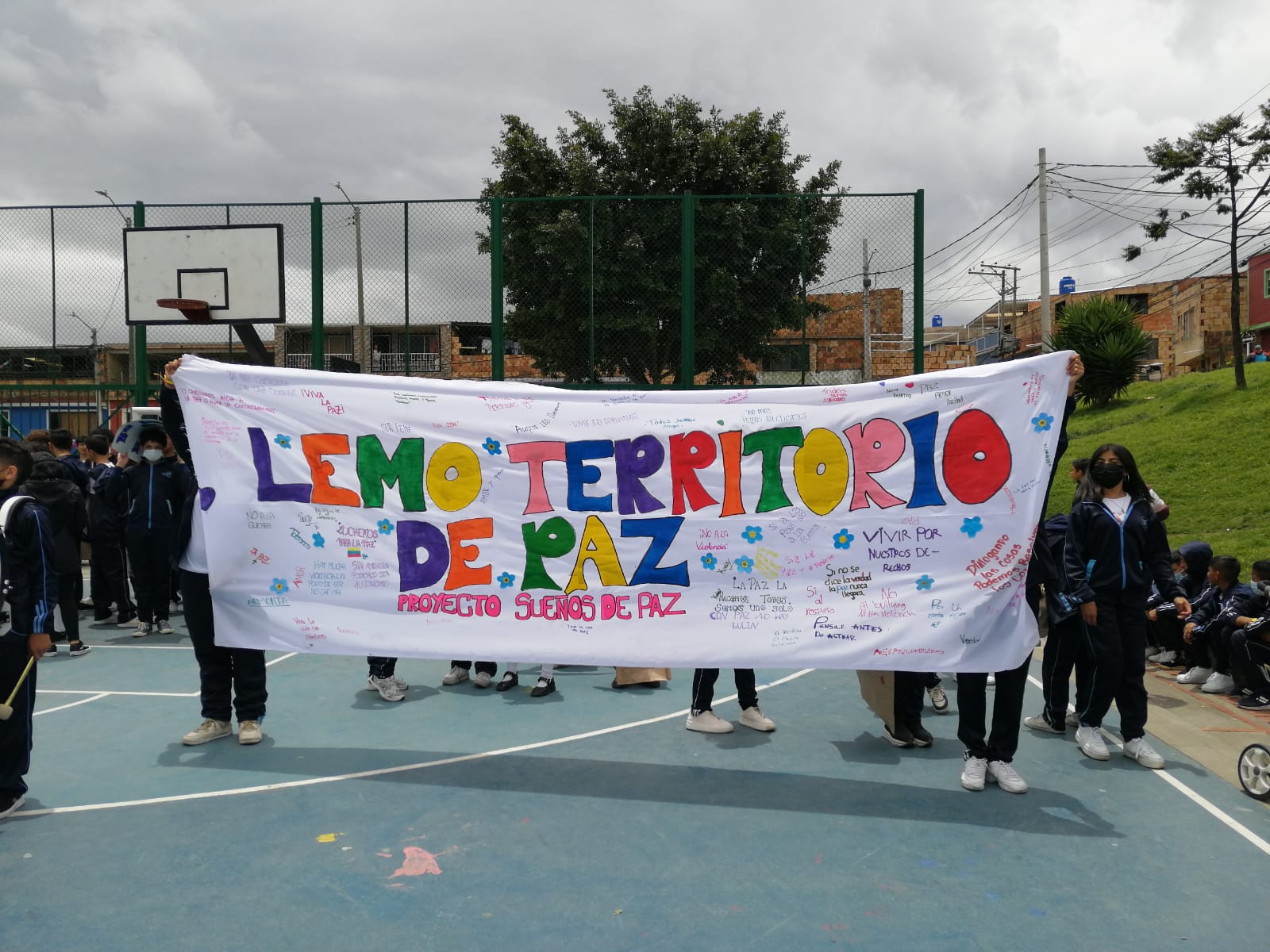 Niños sosteniendo una pancarta sobre la paz.