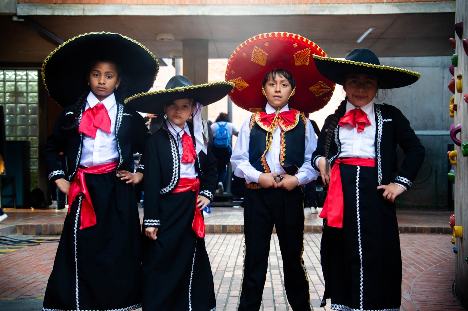 4 estudiantes vestidos de Mariachi , tres niñas y un niño