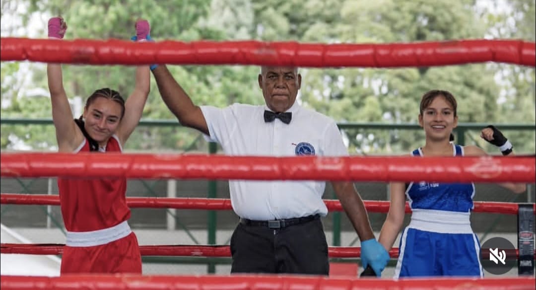 Uniforme rojo, feliz y el referee levantando su brazo izquierdo, el brazo de la campeona nacional